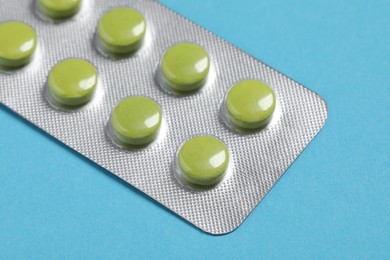 Photo of Pills in blister on blue background, closeup