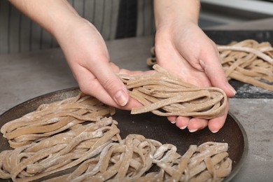 Photo of Woman making homemade soba at table, closeup