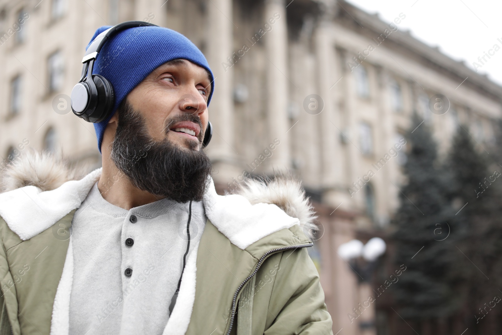 Photo of Mature man with headphones listening to music outdoors