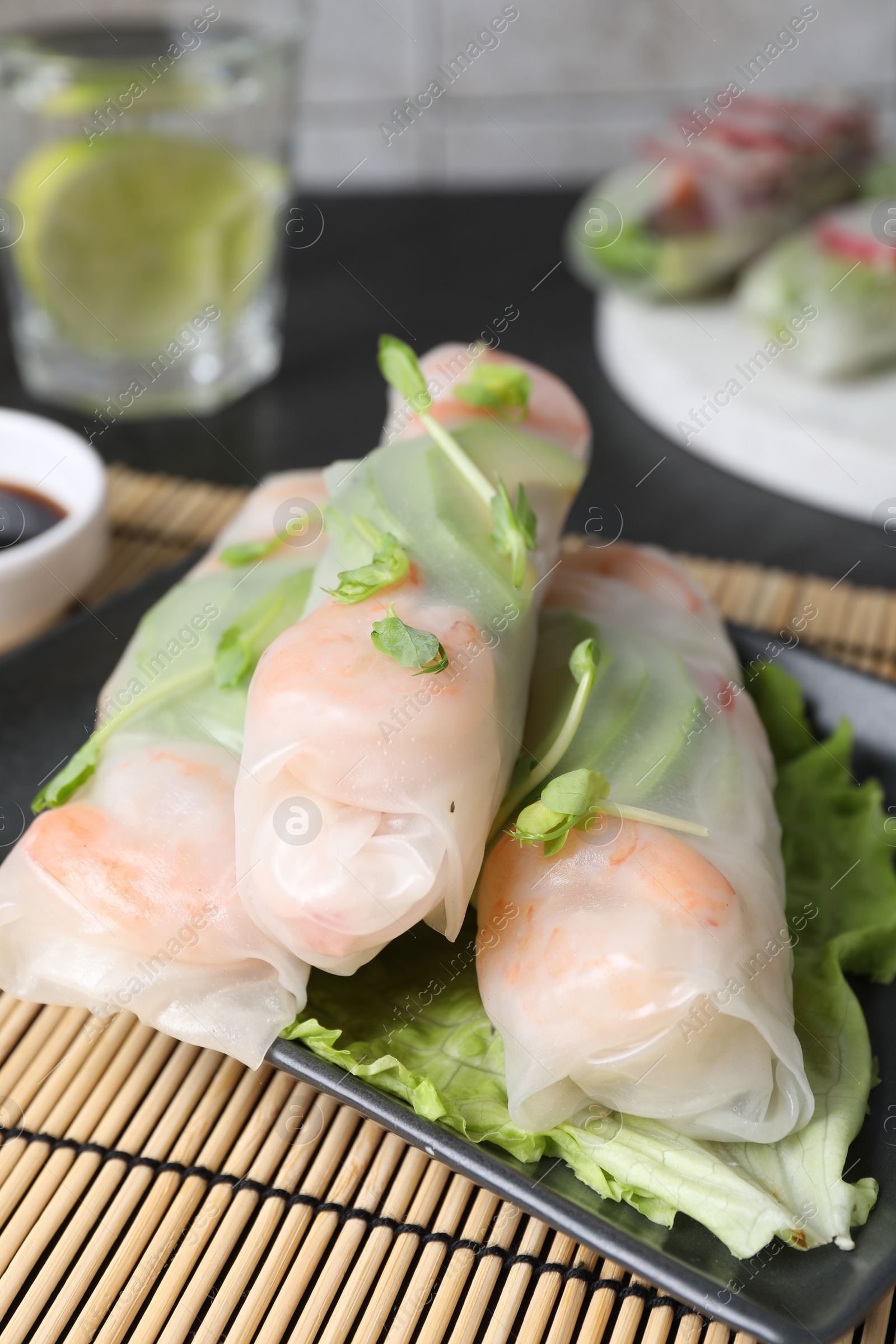 Photo of Delicious spring rolls wrapped in rice paper on table, closeup