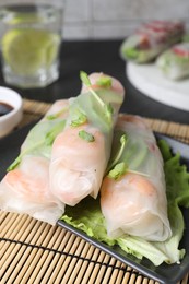 Delicious spring rolls wrapped in rice paper on table, closeup