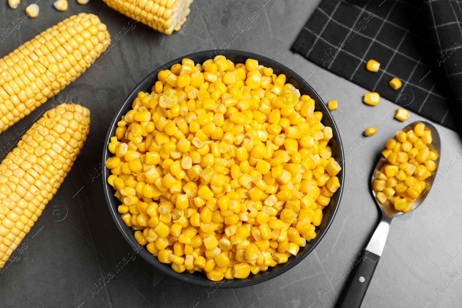 Photo of Delicious canned corn in bowl on grey table, flat lay