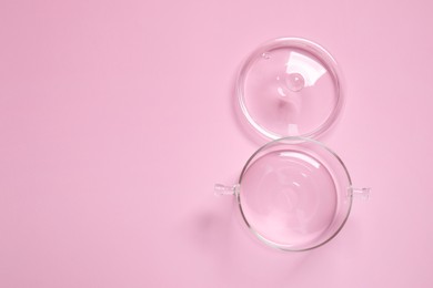 Photo of Empty glass pot and lid on pink background, flat lay. Space for text
