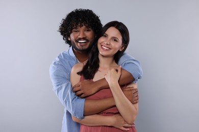 Photo of International dating. Happy couple hugging on light grey background