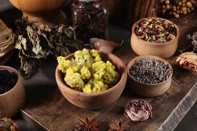 Many different dry herbs, flowers and spices on table