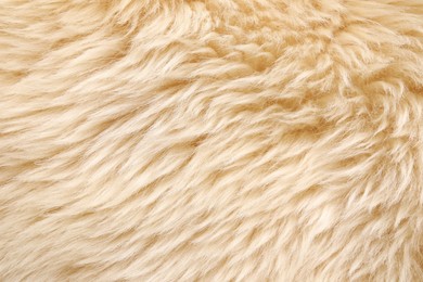 Texture of beige faux fur as background, top view