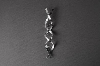 Photo of DNA molecular chain model made of metal on grey background, top view