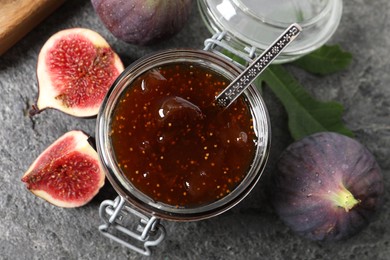 Jar of tasty sweet jam and fresh figs on grey table, flat lay