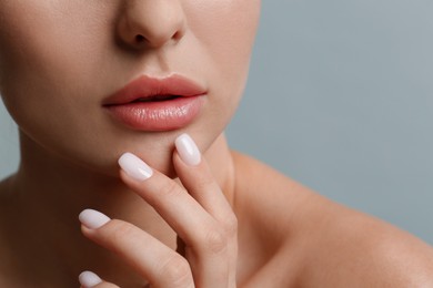 Photo of Woman with beautiful lips on light grey background, closeup