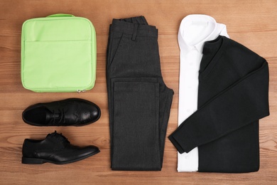 Photo of School uniform for boy on wooden background, top view