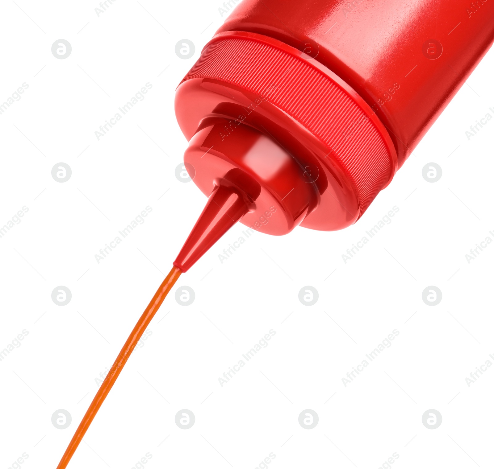 Photo of Pouring tasty red ketchup from bottle isolated on white