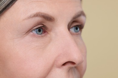 Photo of Senior woman with aging skin on beige background, closeup. Rejuvenation treatment