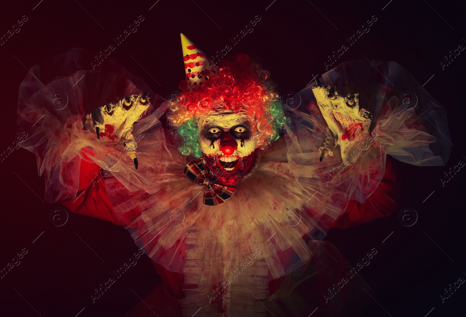 Photo of Terrifying clown in darkness. Halloween party costume