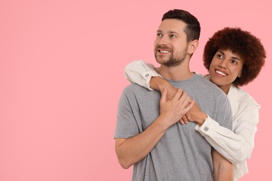 Photo of International dating. Happy couple hugging on pink background, space for text