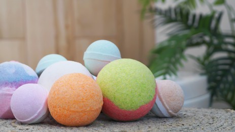 Photo of Many different colorful bath bombs on wicker mat in bathroom