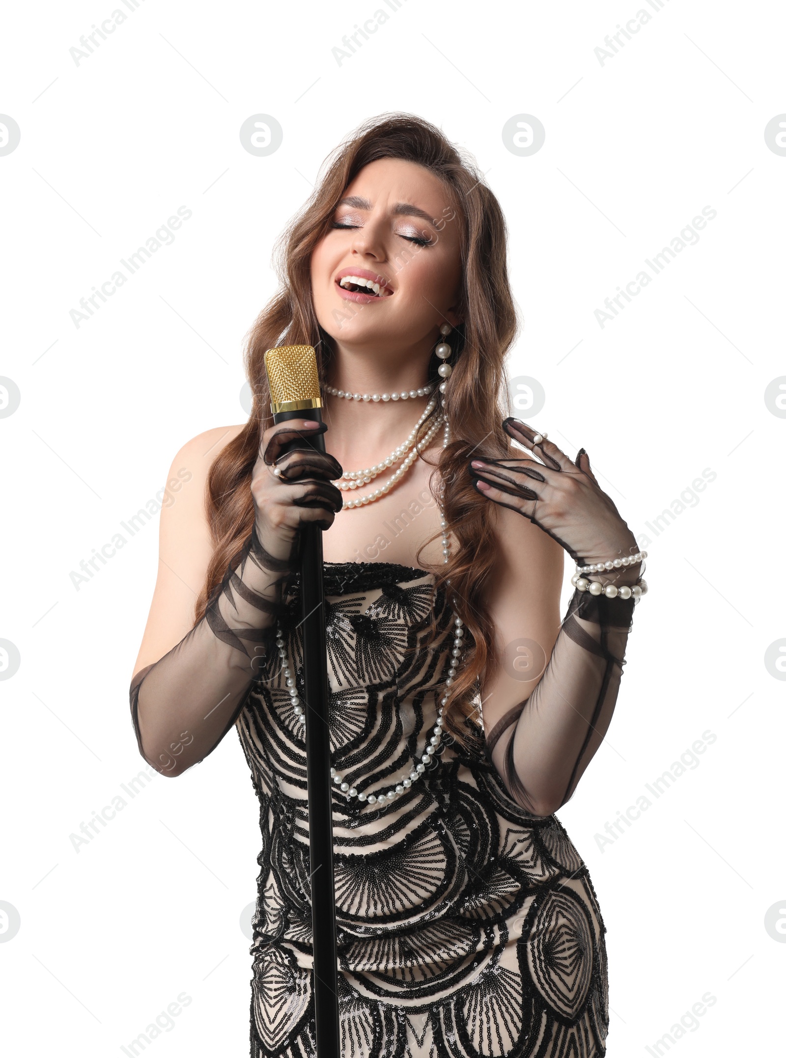 Photo of Beautiful young woman in stylish dress with microphone singing on white background