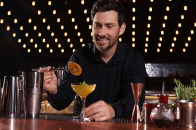 Photo of Bartender preparing fresh alcoholic cocktail in bar