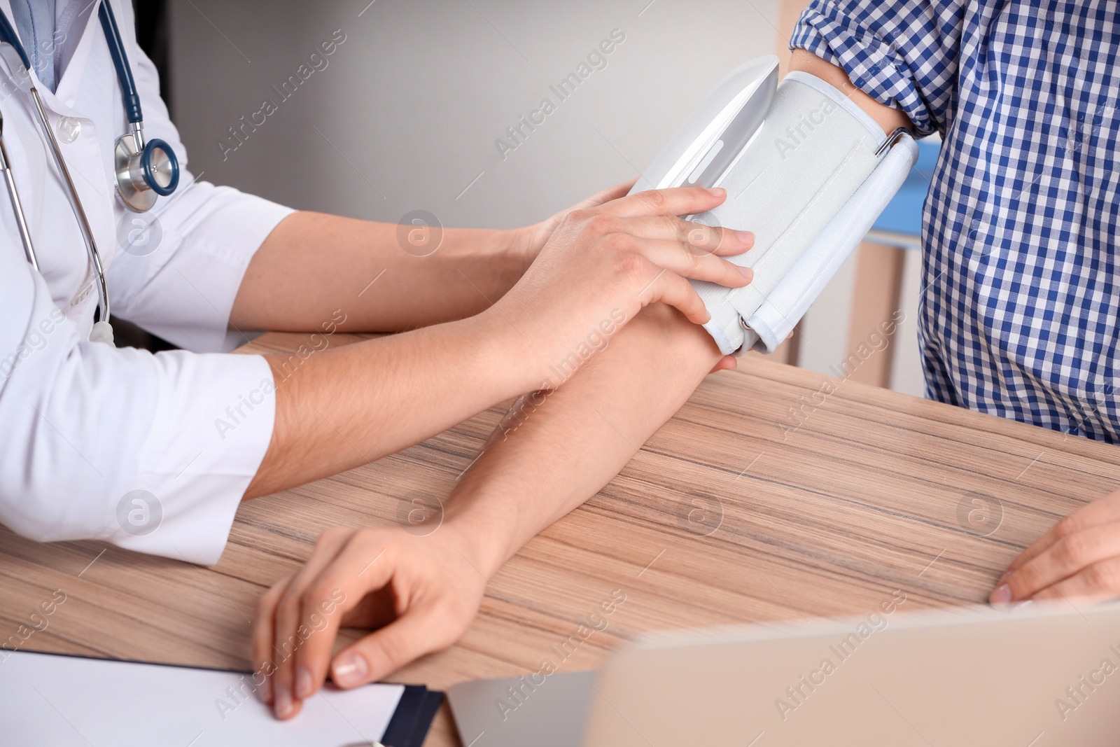 Photo of Doctor measuring blood pressure of woman in clinic, closeup. Medical service