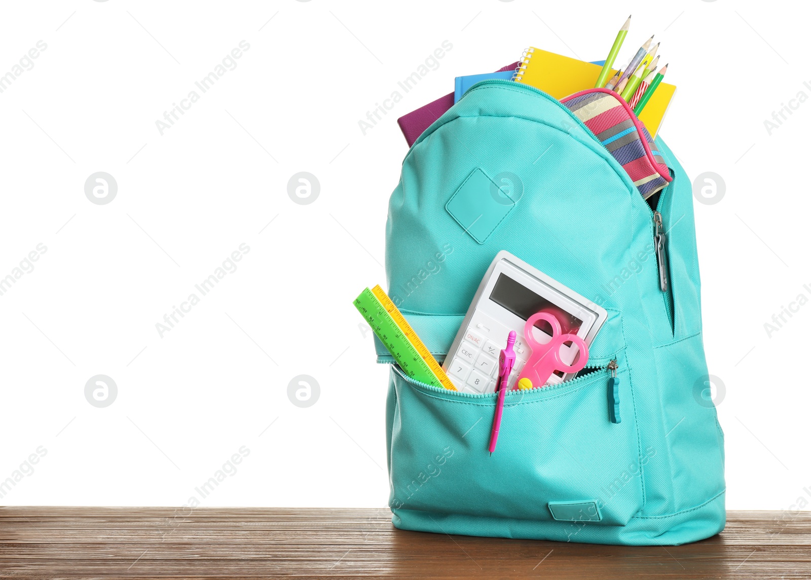 Photo of Stylish backpack with different school stationary on wooden table against white background