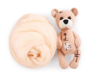 Photo of Needle felted bear and wool isolated on white, top view