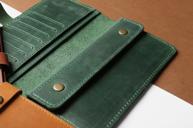 Photo of Open leather wallet on color background, closeup