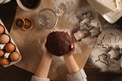 Little child making Christmas cookies at wooden table, top view