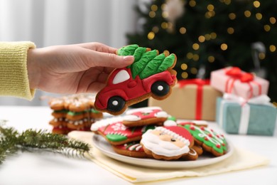 Photo of Woman with decorated Christmas cookie at table, closeup