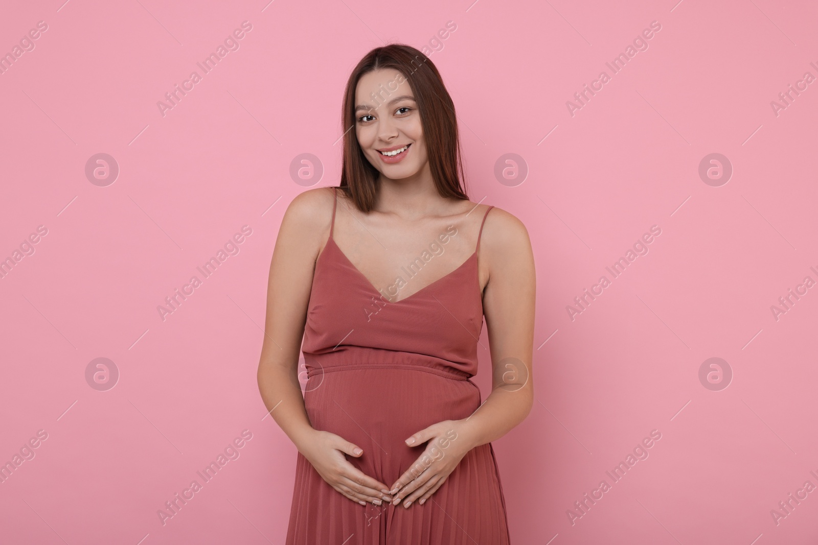 Photo of Beautiful pregnant woman in dress on pink background