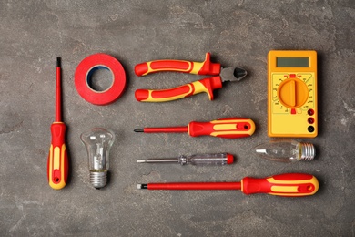 Flat lay composition with electrician's tools on gray background