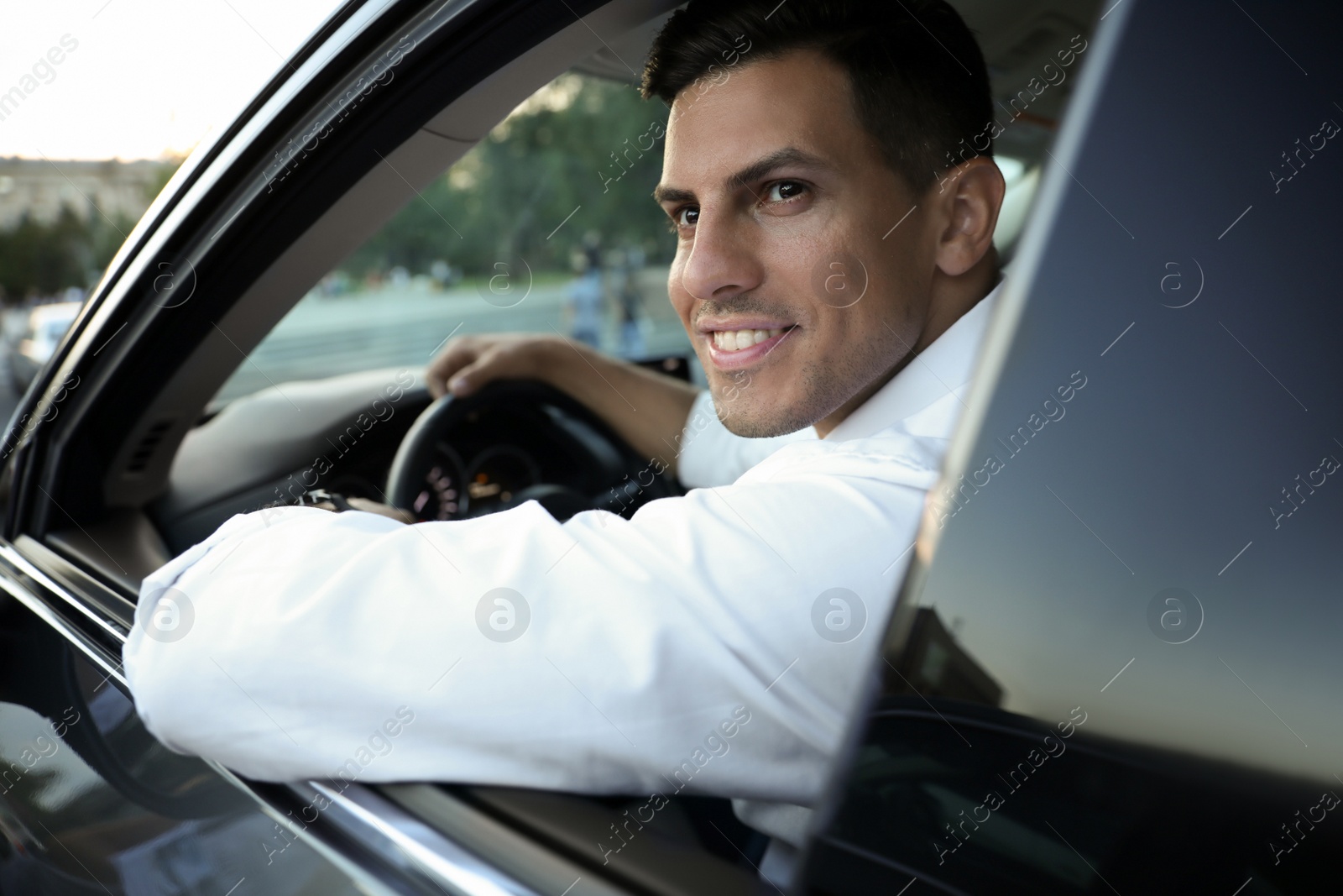 Photo of Handsome man in his modern car, view from outside