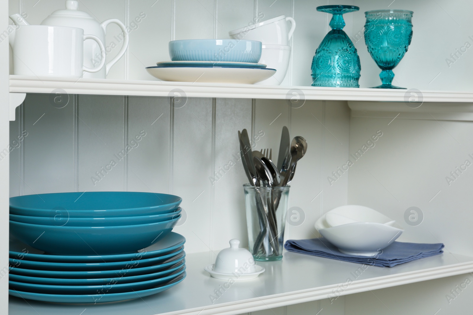 Photo of White shelving unit with set of dishware