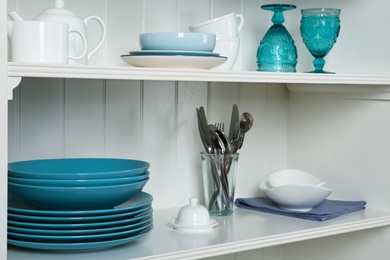 White shelving unit with set of dishware