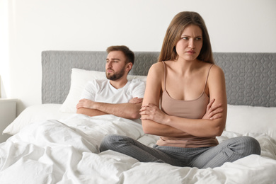 Photo of Unhappy couple with relationship problems after quarrel in bedroom