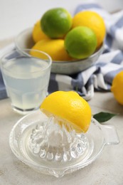 Photo of Glass squeezer with lemon and juice on light table