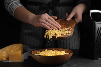 Photo of Woman with grated cheese at table, closeup