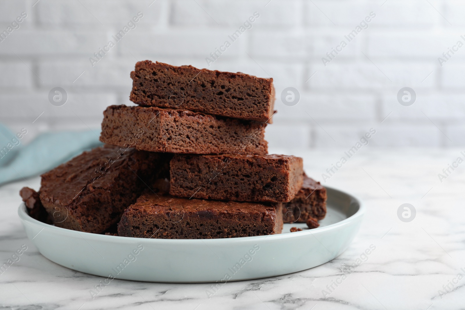 Photo of Delicious chocolate brownies on white marble table