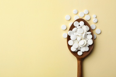 Spoon with different pills on color background, top view. Space for text