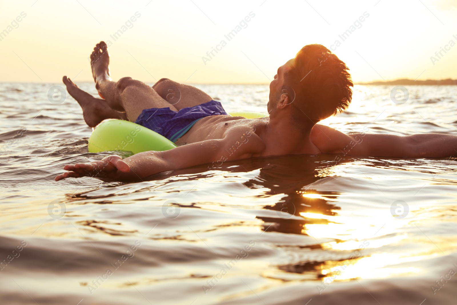 Photo of Young man with inflatable ring in sea