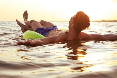 Photo of Young man with inflatable ring in sea