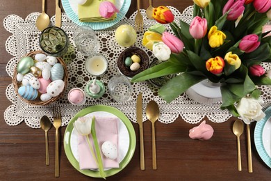 Photo of Festive table setting with beautiful flowers, flat lay. Easter celebration