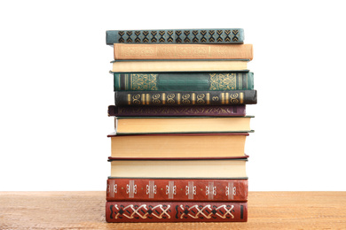 Photo of Stack of old vintage books on wooden table against white background