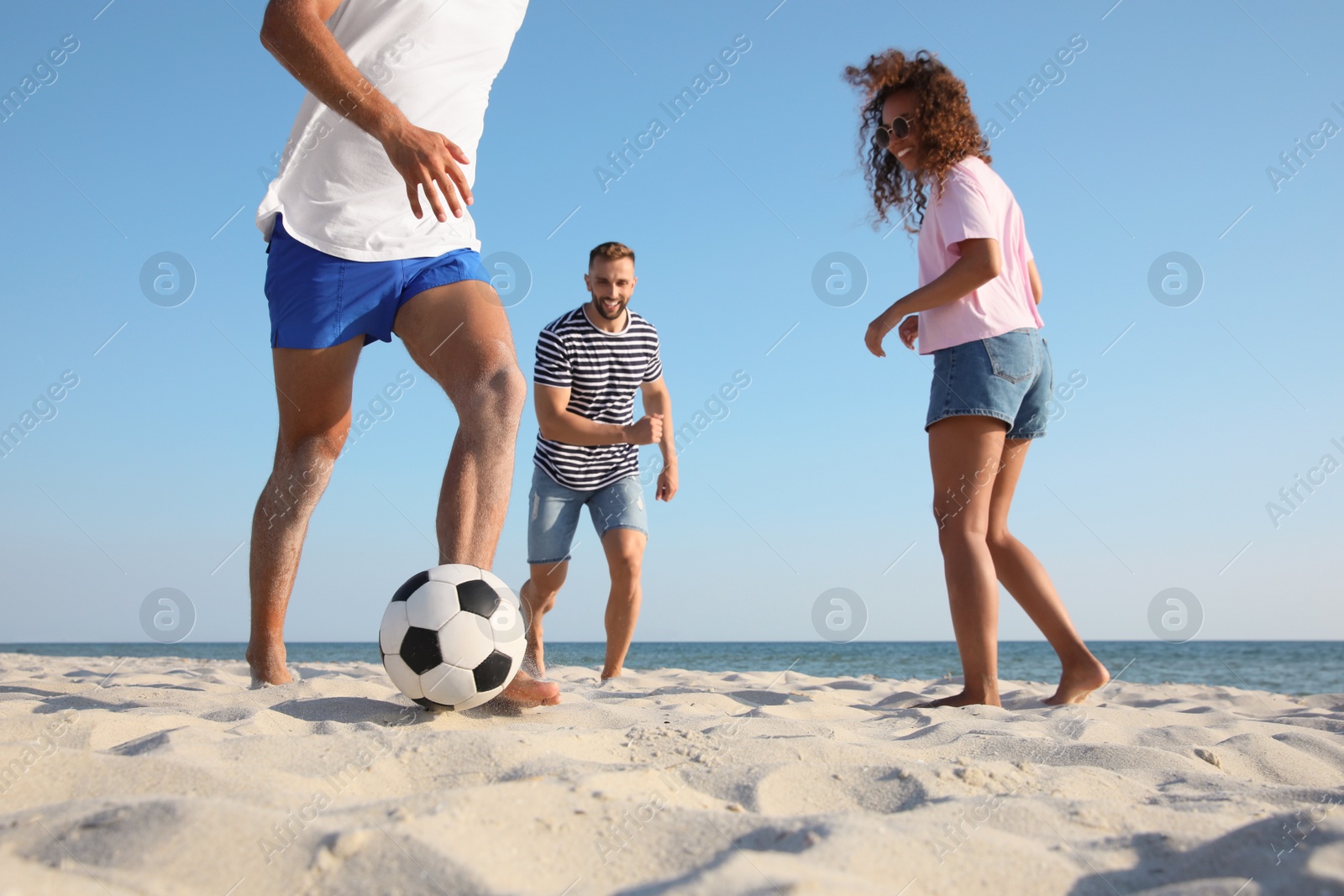 Photo of Group of friends playing football on beach