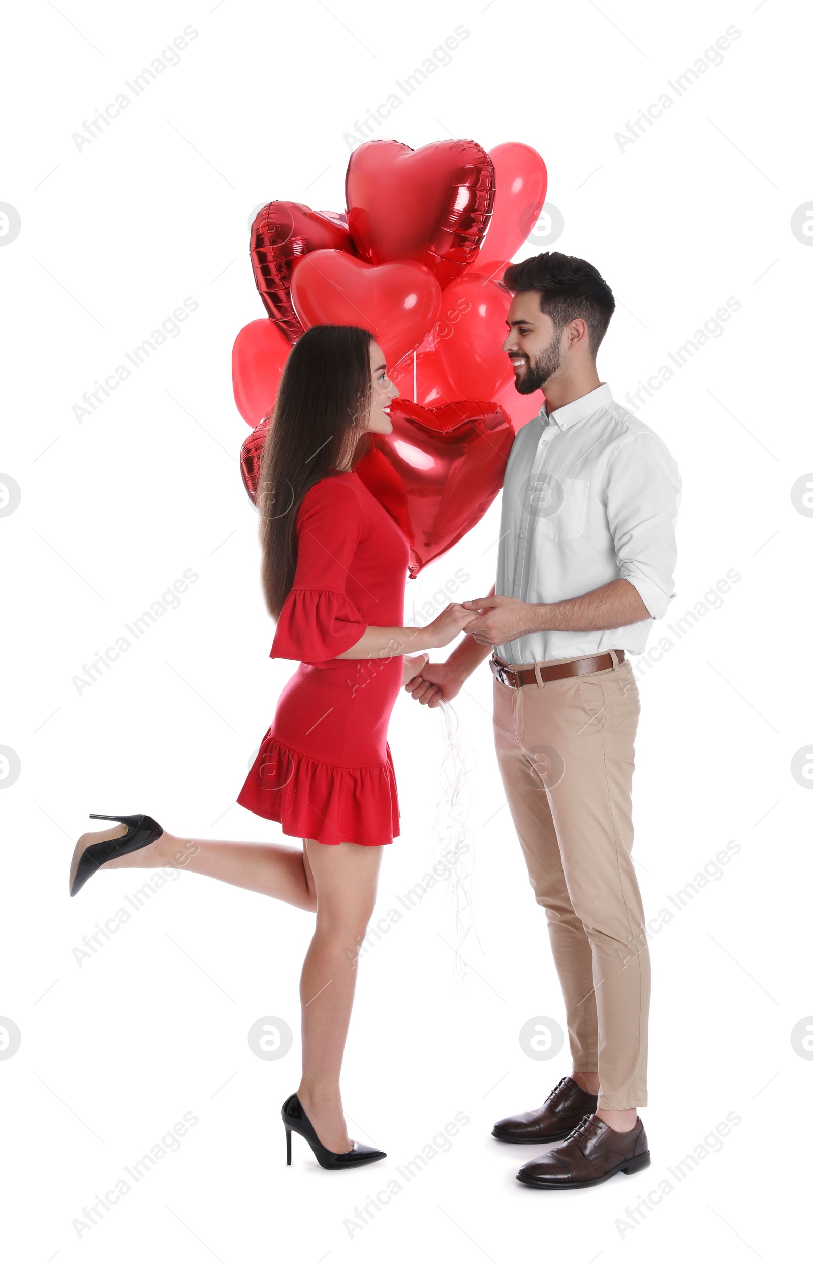 Photo of Happy young couple with heart shaped balloons isolated on white. Valentine's day celebration