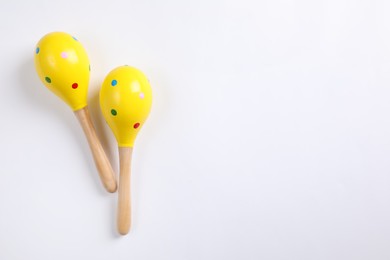 Photo of Bright wooden maracas on white background, top view. Montessori musical toy