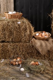 Photo of Fresh chicken eggs and dried straw bales in henhouse