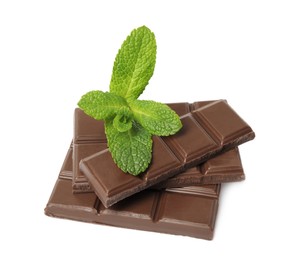 Tasty milk chocolate pieces with mint on white background