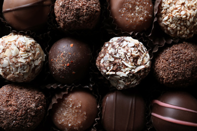 Photo of Different tasty chocolate candies as background, top view
