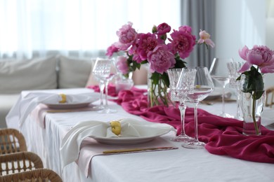 Beautiful table setting with pink peonies in dining room