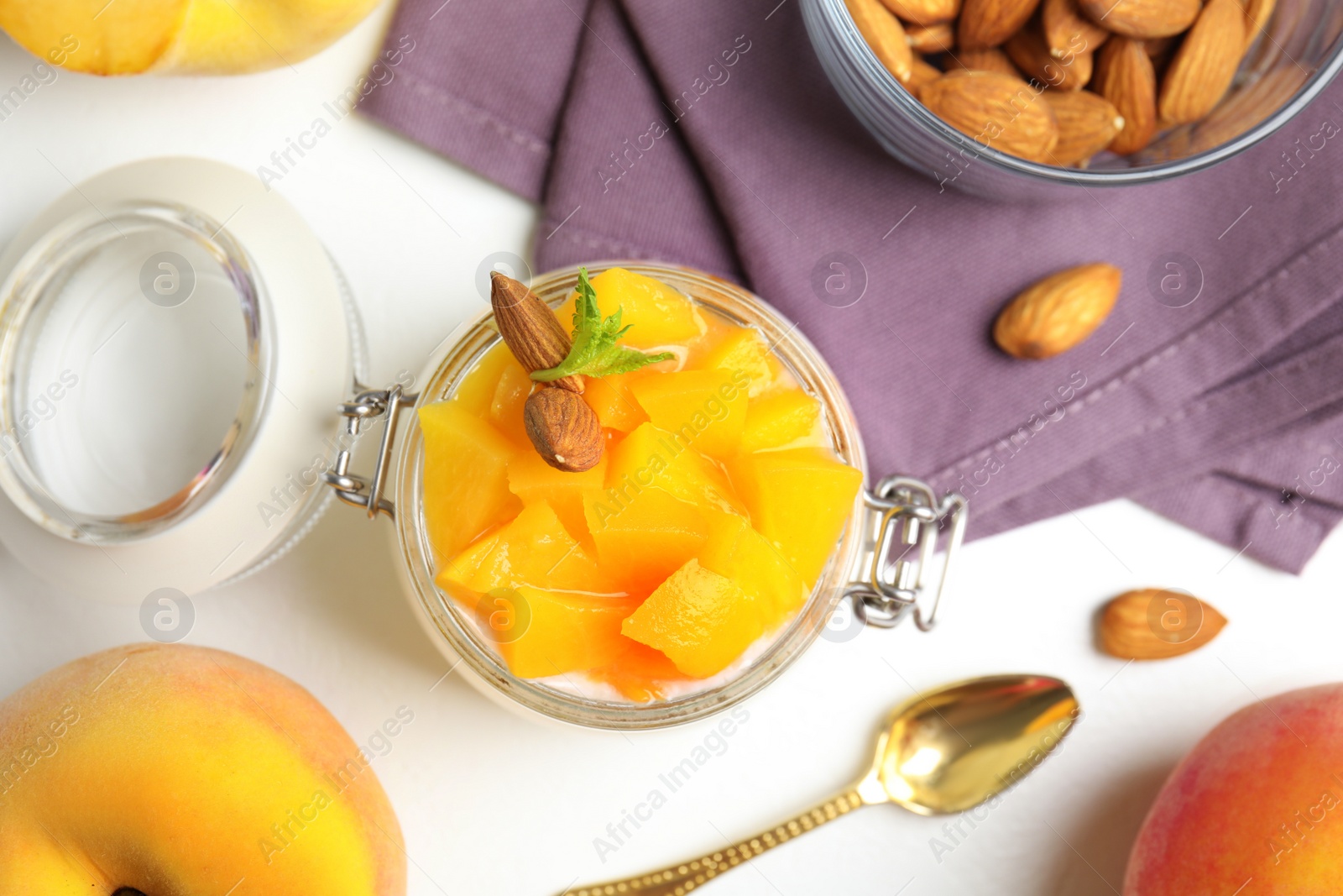 Photo of Tasty peach dessert with yogurt served on white table, flat lay