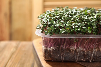 Photo of Fresh organic microgreen on wooden table, closeup